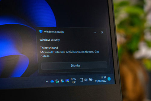 A monitor displaying a Windows Security threat warning.