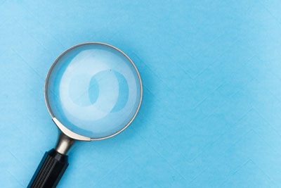Magnifying glass over a pale map.
