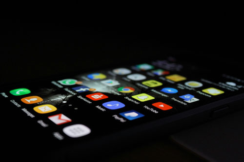 Smartphone showing app icons on a dark screen.