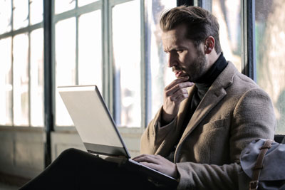 A businessman viewing information on a laptop.